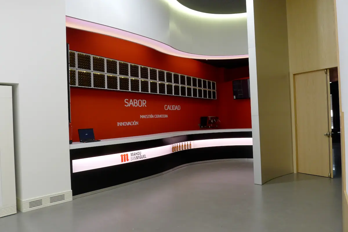 Mostrador de recepción de Mahou San Miguel, diseño interior con acabados metálicos.